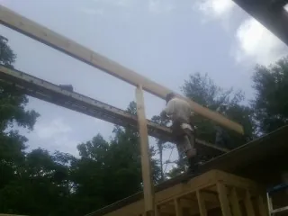 Carpenter setting a ridge beam over a new addition frame — Ice Dam Removal by Roofing Brothers in Advent