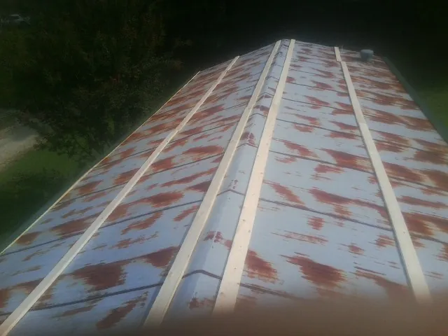 Rusted metal roof panels with new wood purlins before replacement — Storm Damage Roof Repair in Advent by Roofing Brothers