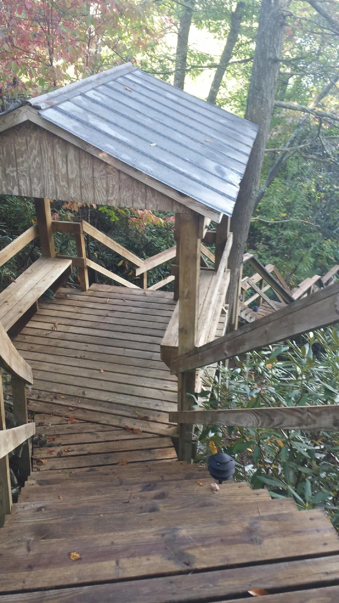 Metal roofed shelter over wooden steps on a wooded walkway — Skylight Repair & Installation work by our crew in Advent