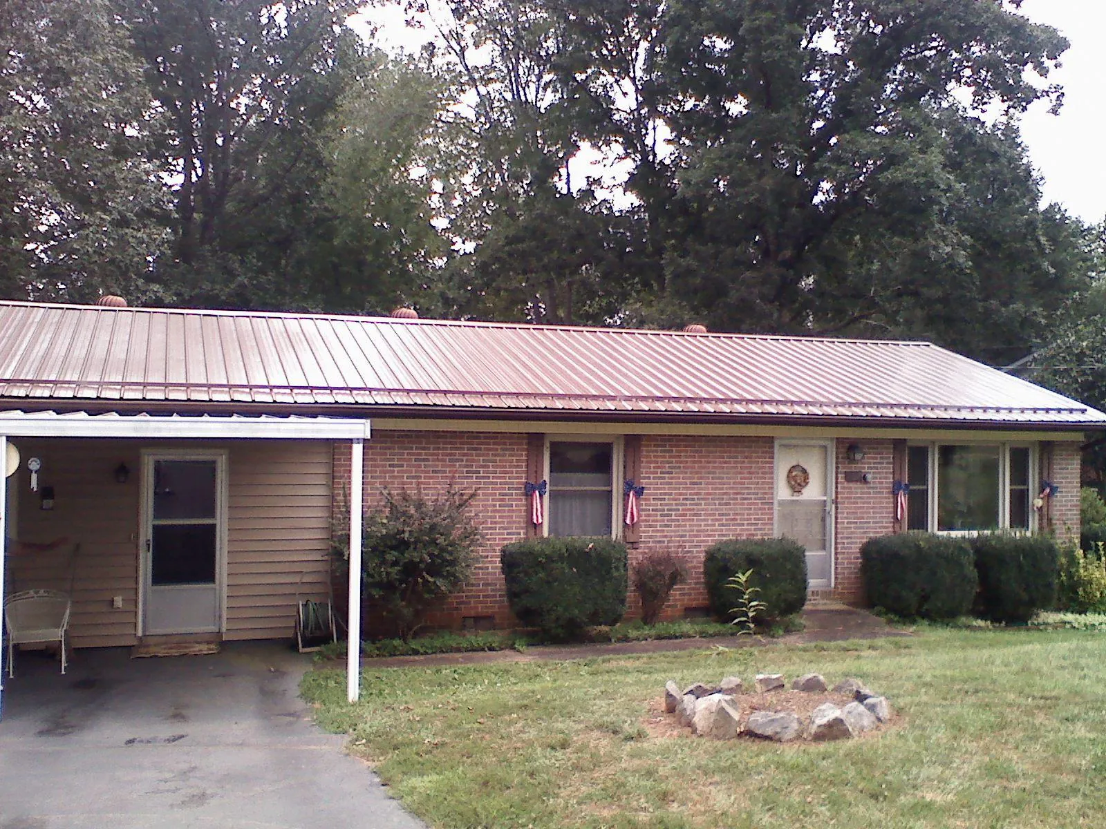 Bronze metal roof and carport on a brick ranch home — Roof Repair work by our crew in Advent